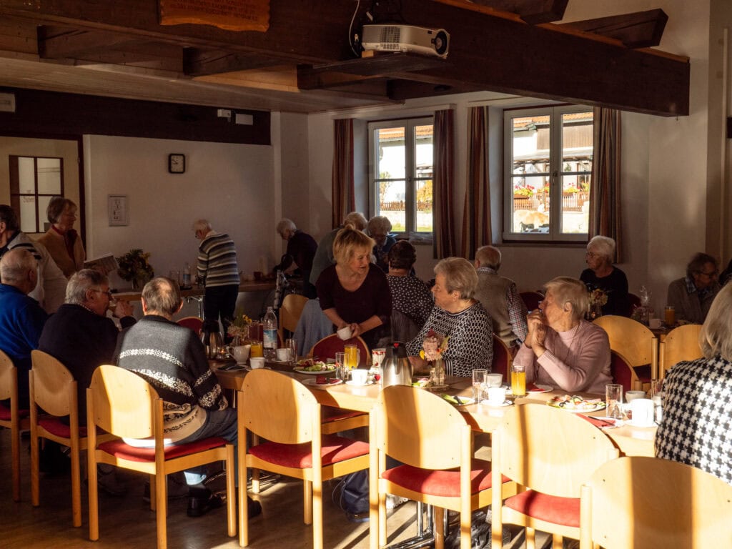 Alle Senioren genießen ihr Frühstück und unterhalten sich angeregt.