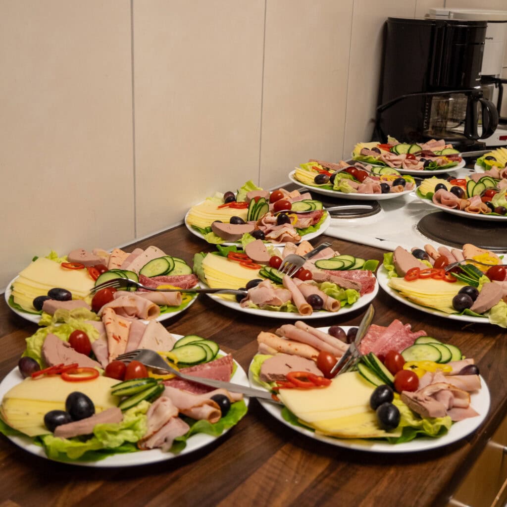 Ganz viele Teller mit Wurst und Käse stehen für das Seniorenfrühstück parat.
