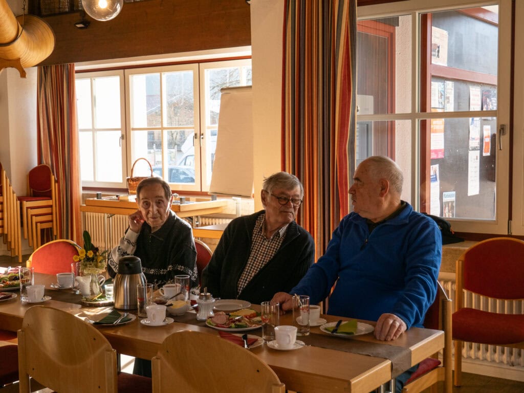 Zwei Senioren sitzen am Tisch beim Frühstücken.