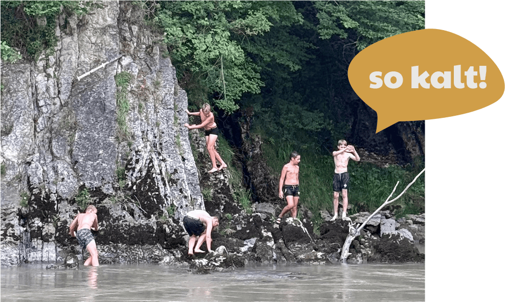 Kinder baden an der Ache.
