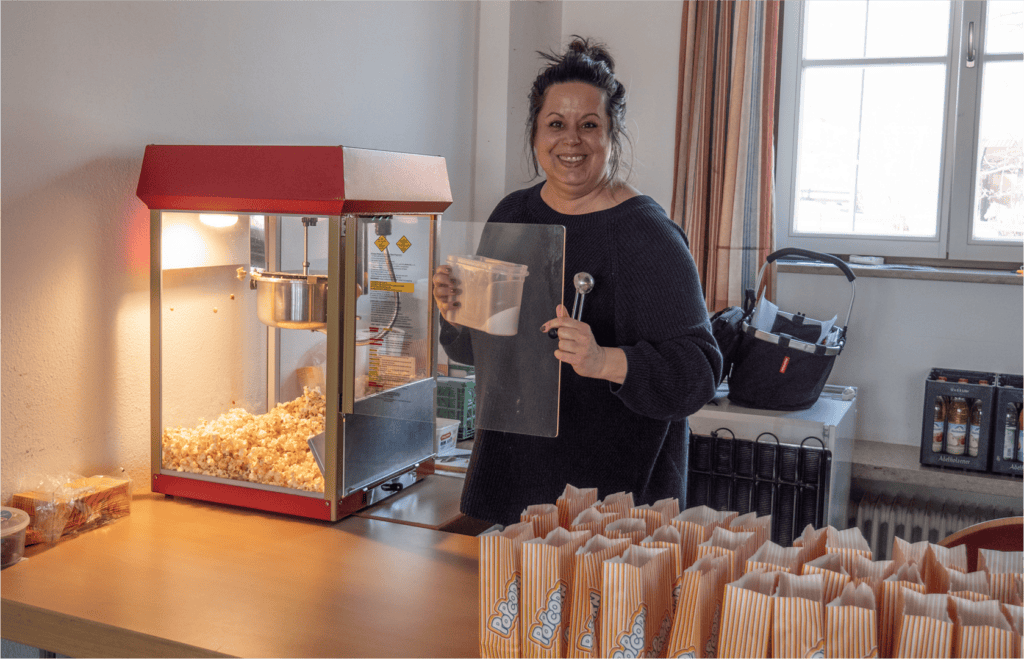 Nadine steht vor der Popcornmaschine.